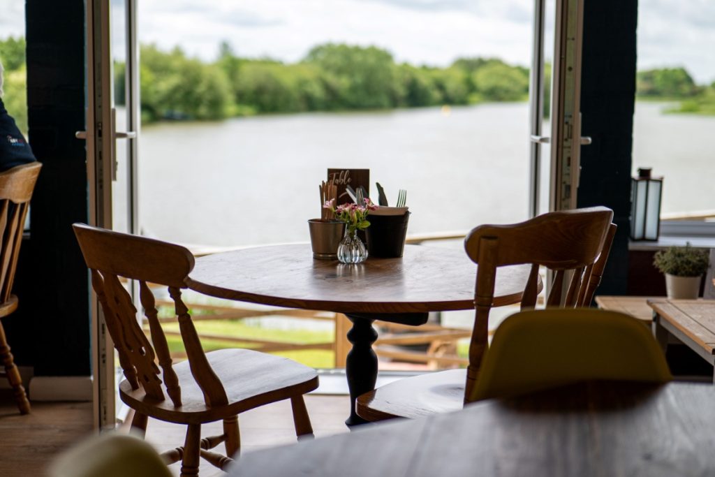 Empty round cafe table with two chairs with view of a lake