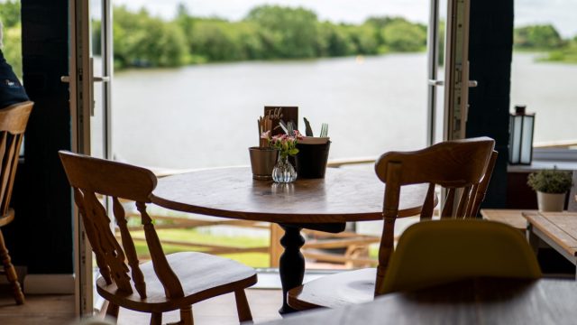 Empty round cafe table with two chairs with view of a lake