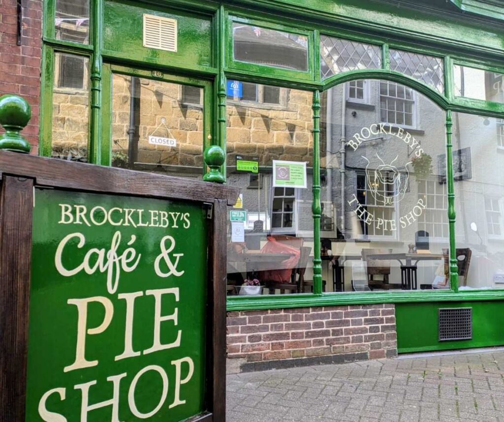 Brockleby’s Café & Pie Shop storefront with green frame, closed sign, and outdoor sandwich board