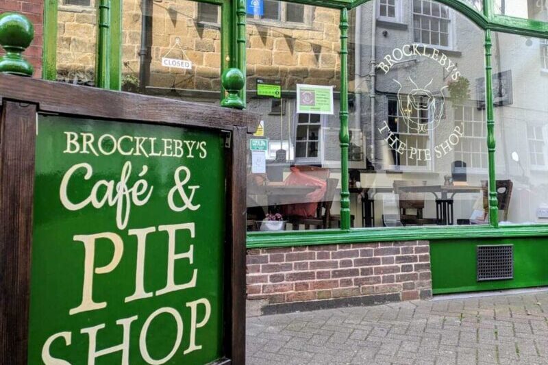 Brockleby’s Café & Pie Shop storefront with green frame, closed sign, and outdoor sandwich board