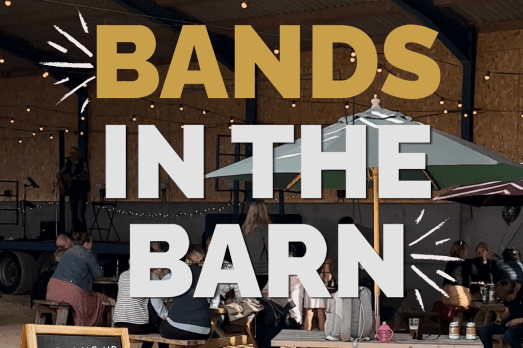 People in an open barn sitting at picnic benches. Display text - Bands in the barn.