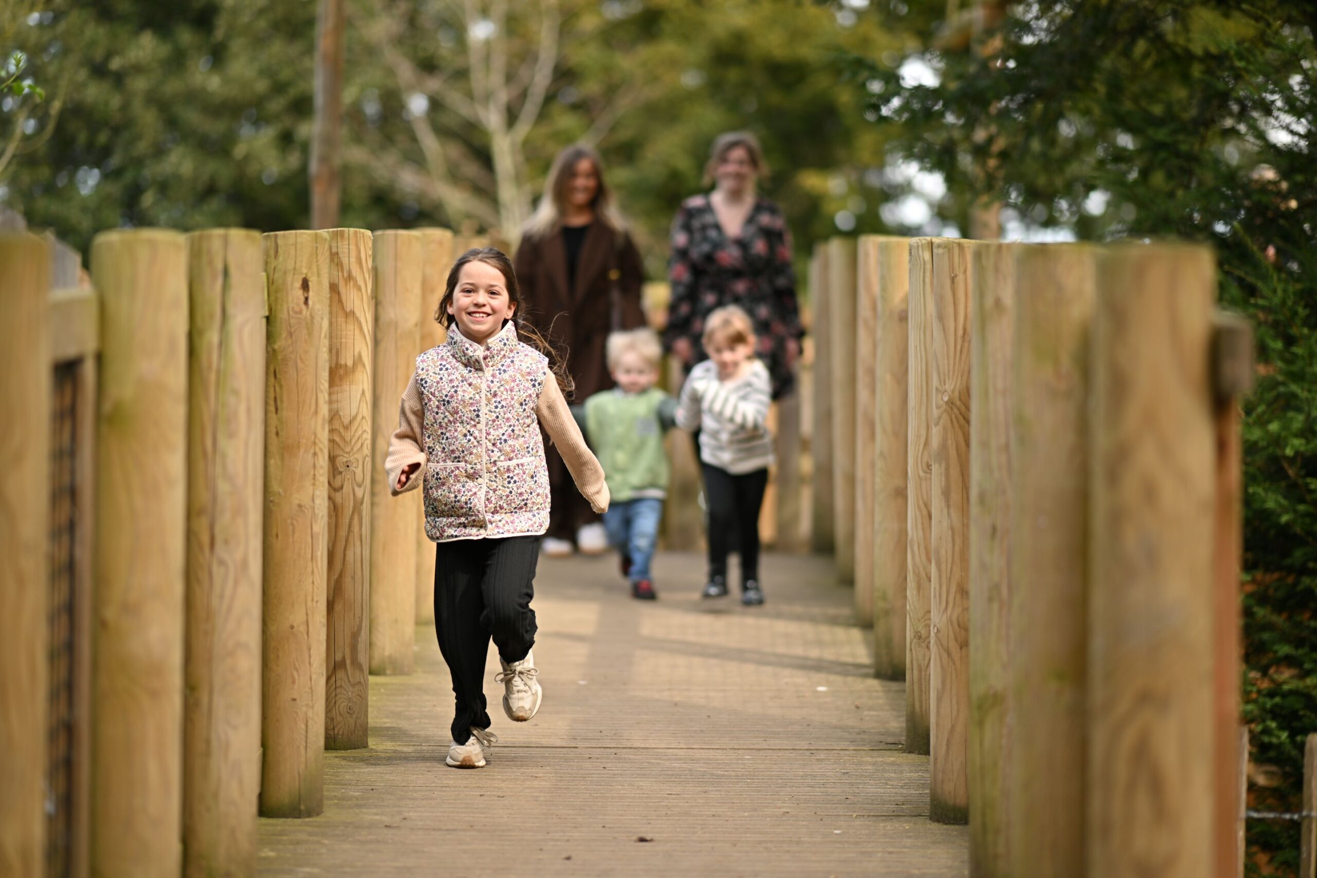Child running on a wooden bridge