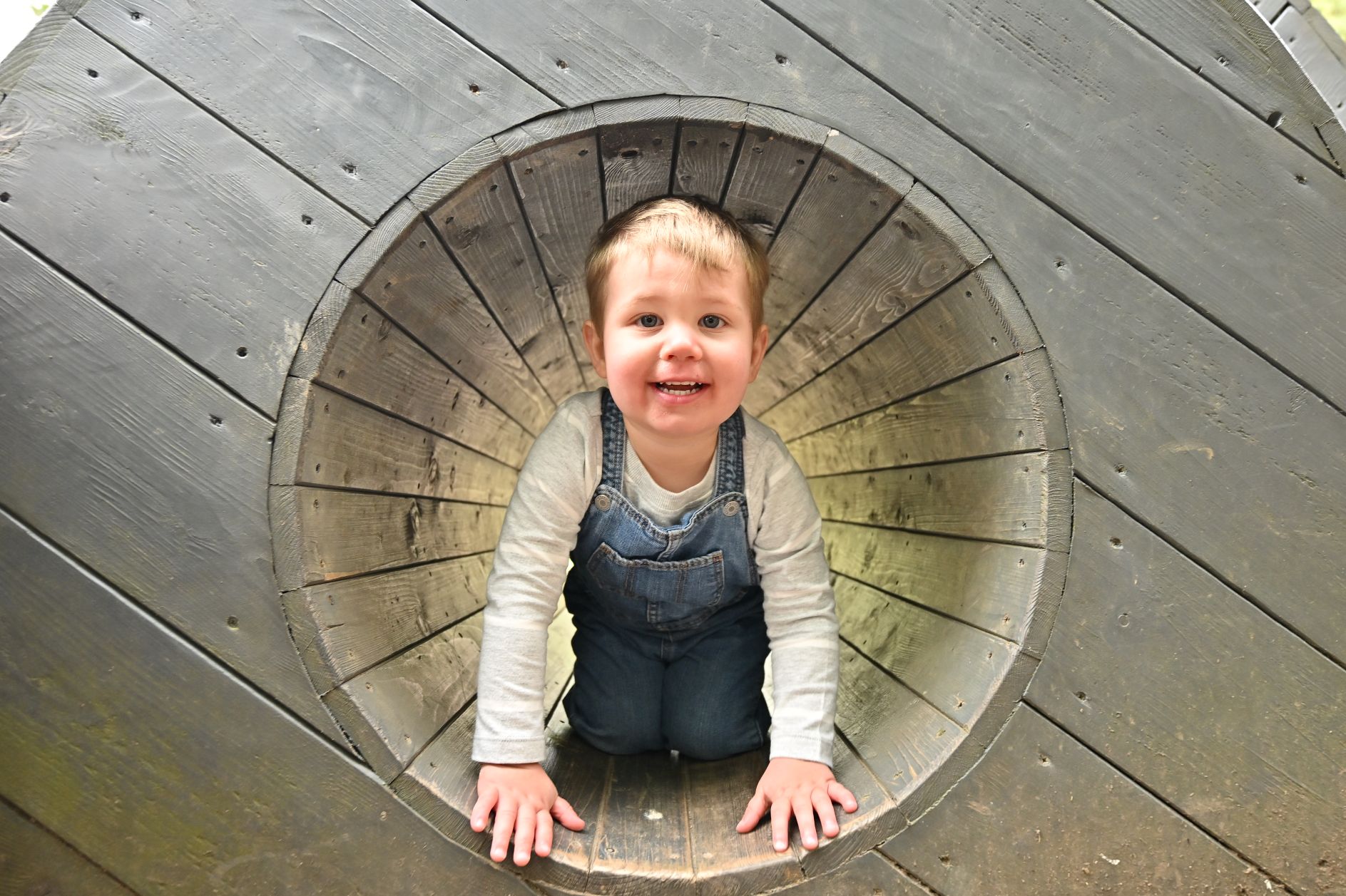 Small child crawling in a tunnel in an adventure playground