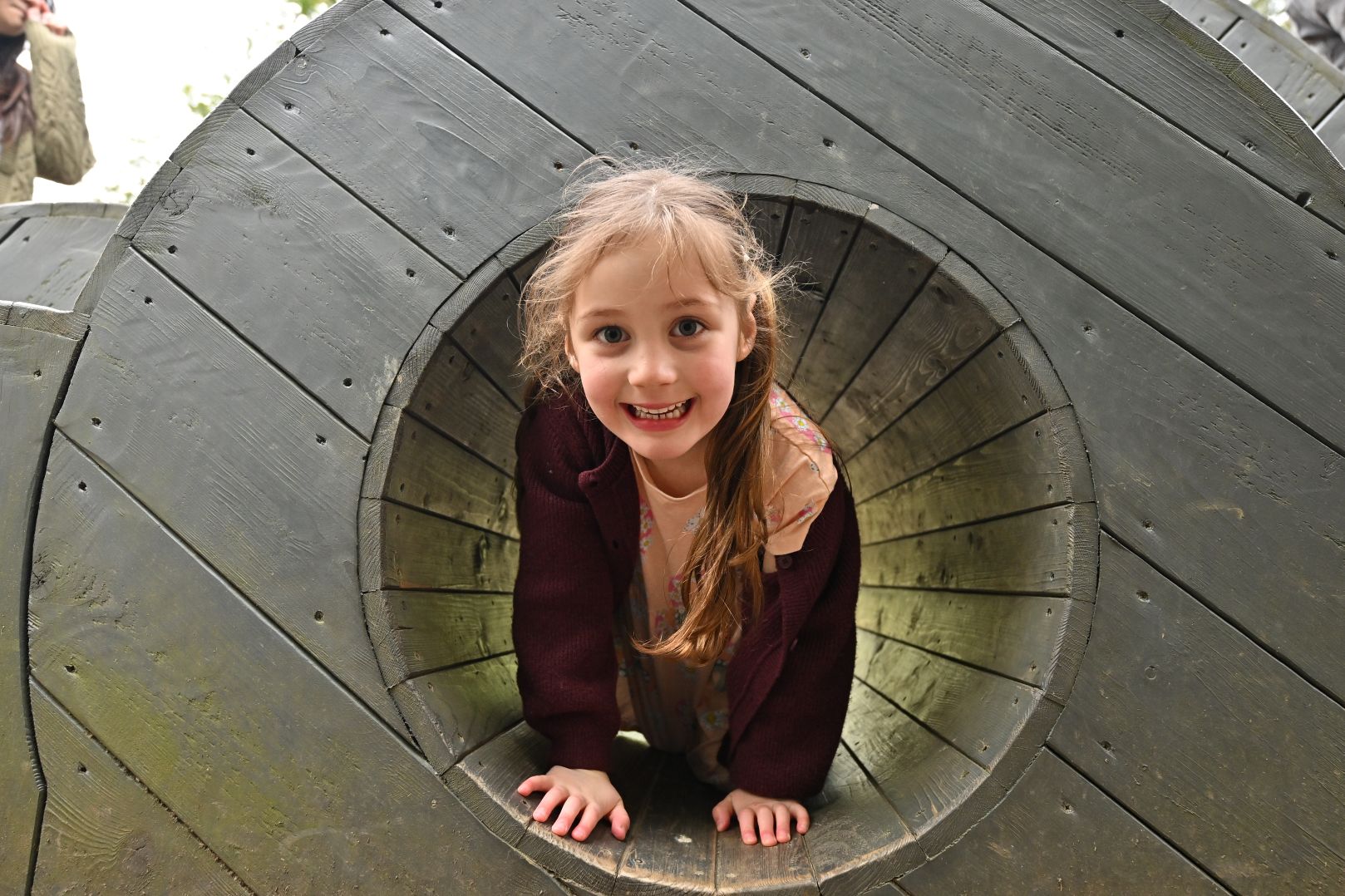 Small Girl in a wooden tunnel in adventure playground