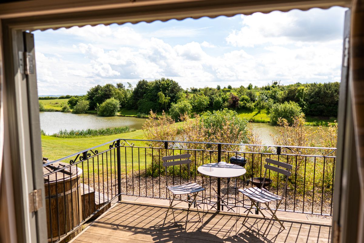Deck seating overlooking lakes and countryside at Fair Farm Hideaway, Leicestershire.