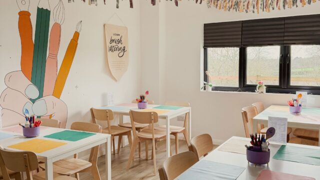 Creative workshop space at The Makers Millhouse with craft tables, art supplies and colourful wall illustrations.