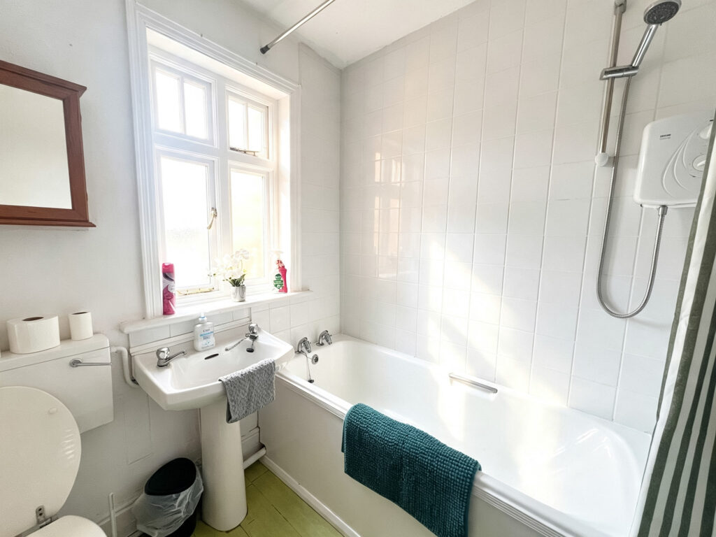 Bright bathroom with bath, shower and sink.