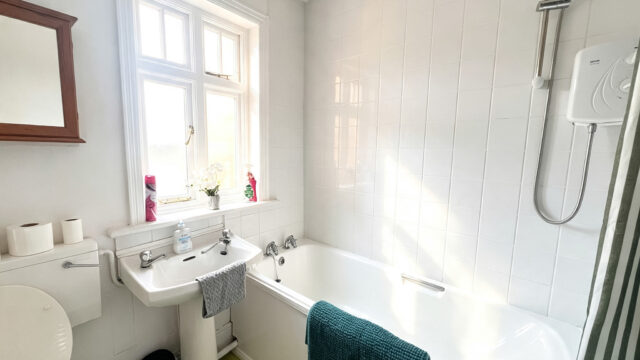 Bright bathroom with bath, shower and sink.